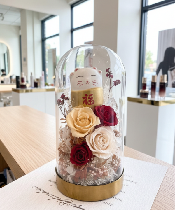 招財貓永生花玻璃罩開幕禮，搭配紅色玫瑰、奶油白玫瑰與金色底座，適合美容工作室、美甲美睫店與醫美診所開幕祝賀
