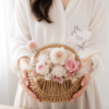 女生雙手捧著粉白系永生花提籃，花籃置中於畫面，搭配韓系白色穿搭與柔和自然光